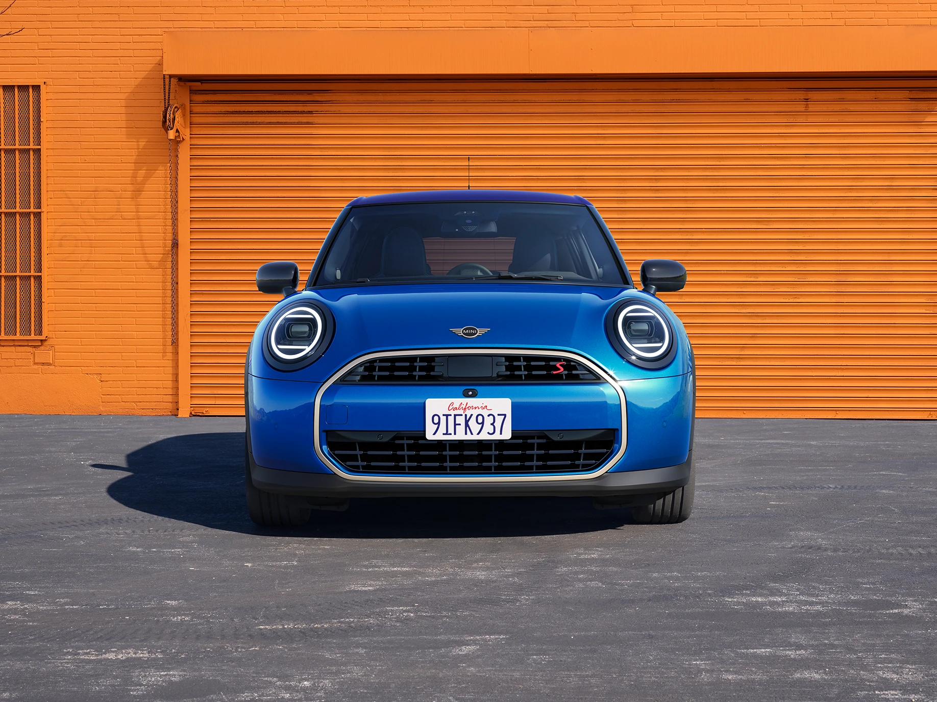 Frontansicht eines MINI Cooper 5-Türer in Icy Sunshine Blue mit Dach in Multitone Blue.