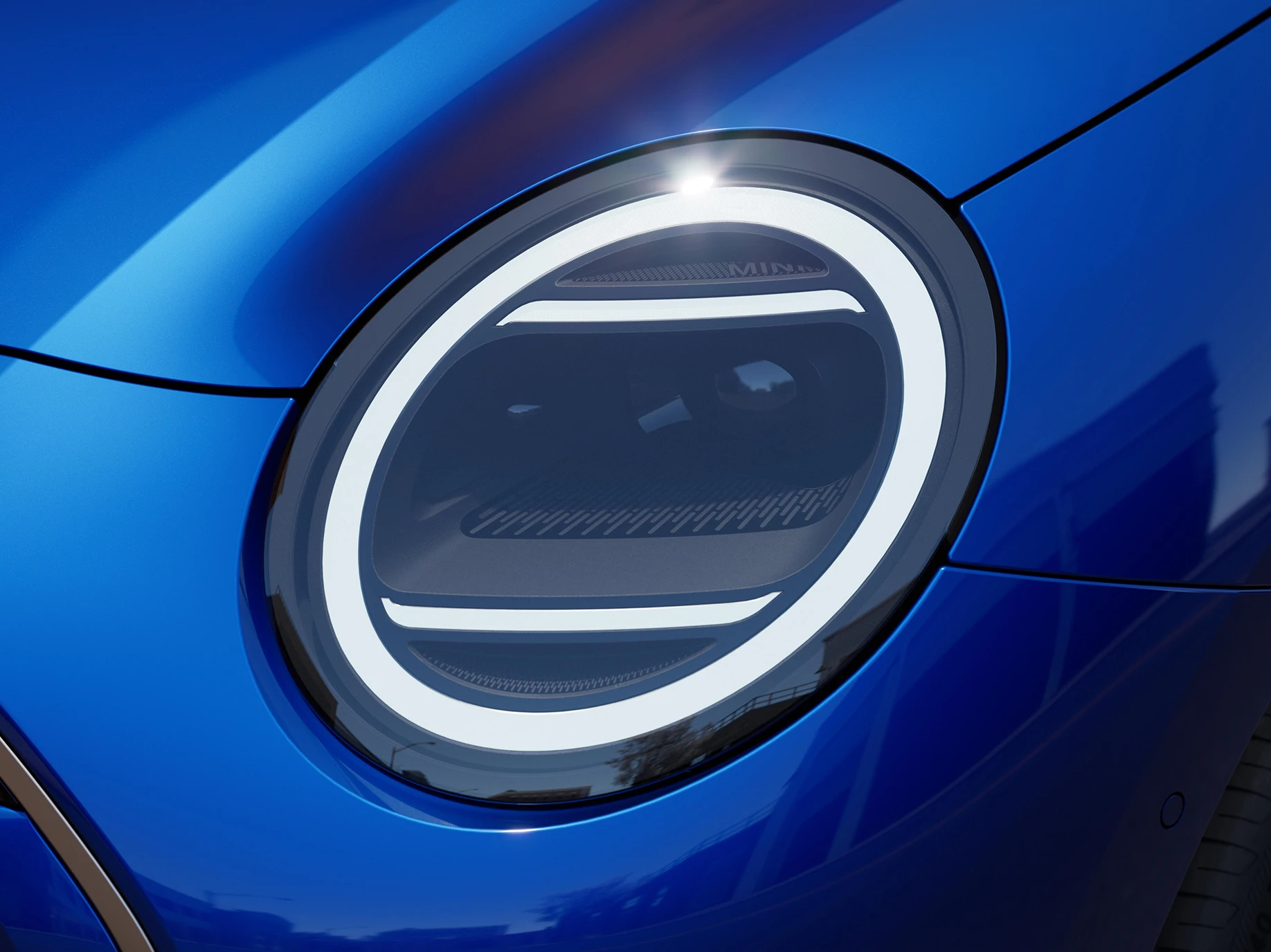 Nahaufnahme der Scheinwerfer eines vollelektrischen MINI Cooper im Favoured Trim.