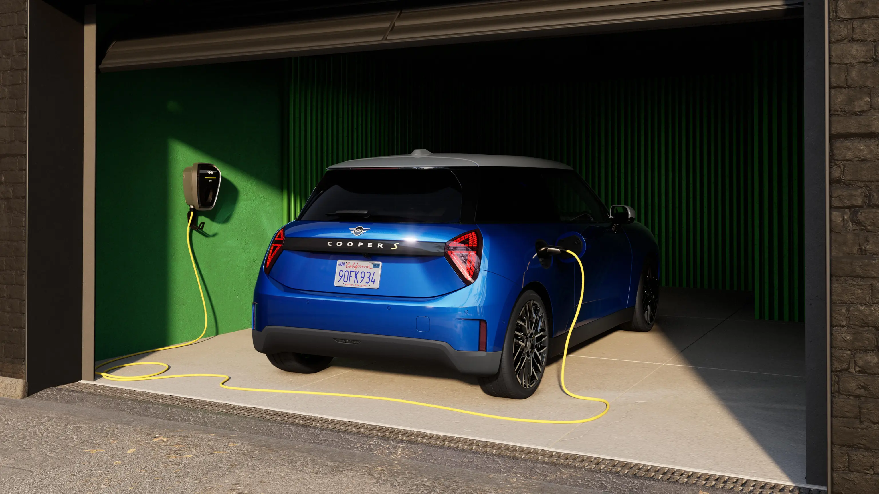 Heckansicht des vollelektrischen MINI Cooper in Blazing Blue in einer Garage mit Ladekabel
