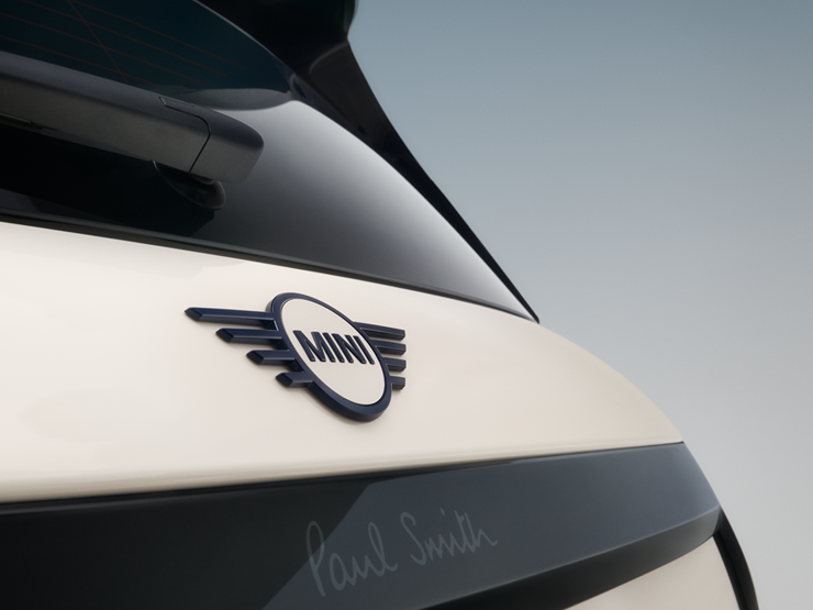 Nahaufnahme des Emblems am Heckflügel des vollelektrischen MINI Cooper Paul Smith Edition in Inspired White.