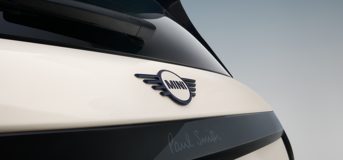 Nahaufnahme des Emblems am Heckflügel des vollelektrischen MINI Cooper Paul Smith Edition in Inspired White.